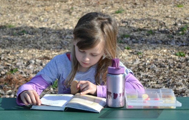 Maia reading at the park